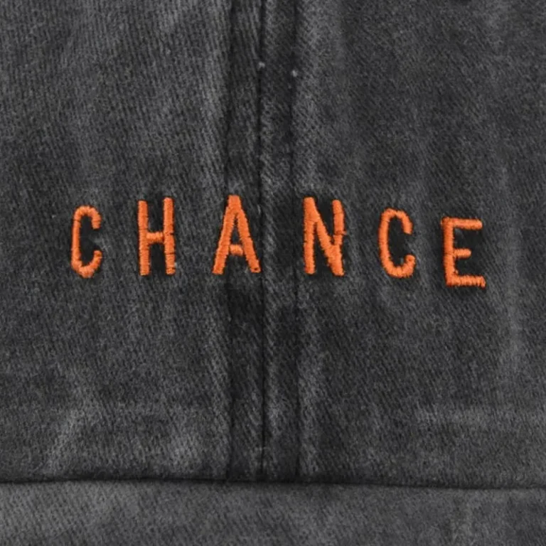 Close-up of orange logo embroidery on a washed cap