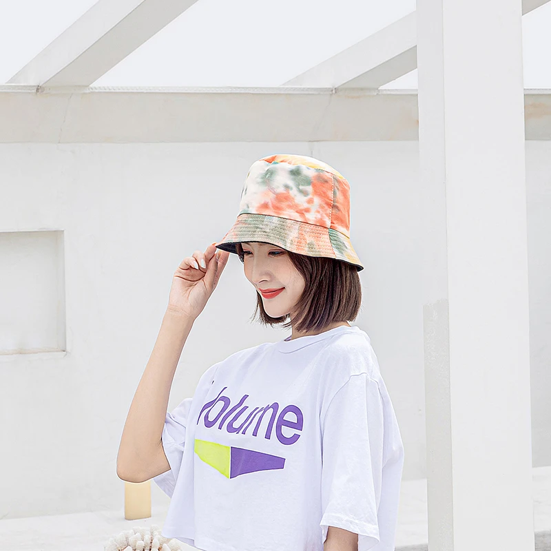 Woman adjusting a tie-dye fisherman bucket hat