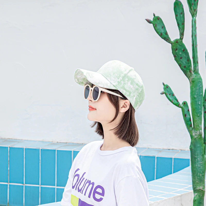 Woman wearing a green tie-dye baseball cap