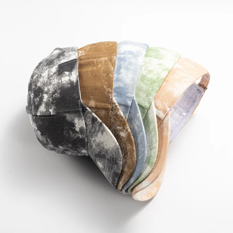 Stack of tie-dye baseball caps in several colors