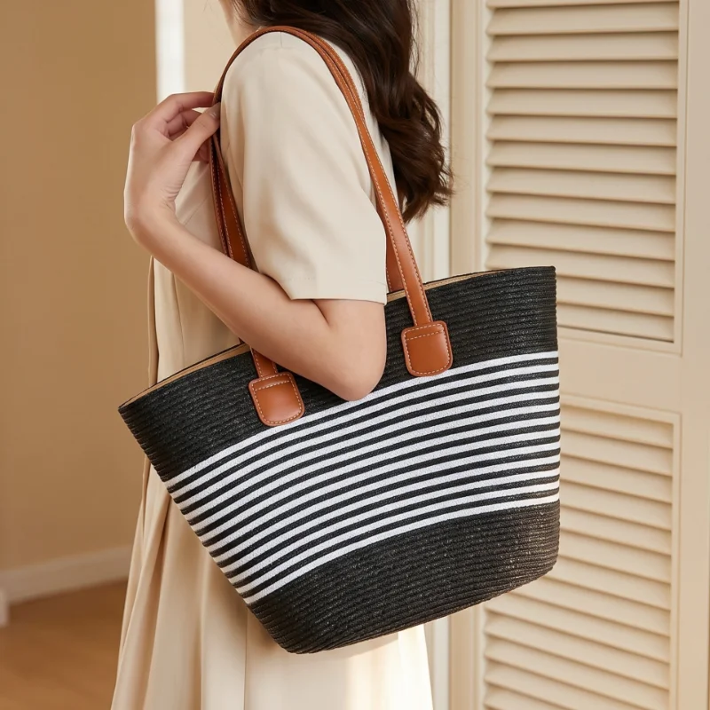 Woman carrying a black striped straw shoulder bag